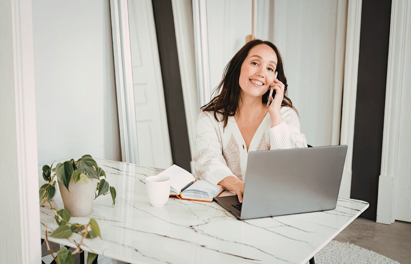 Self-employed woman smiling while on a call at her home office